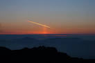 the coast the images catches a con trail illuminated by the setting sun - via Daymix
