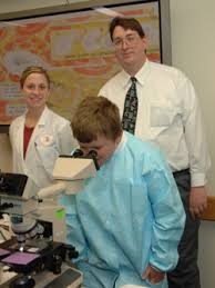 CC DLM hematologist Jenna Protzko helps Timmothy McKeeby and his dad, CC CIO Dr. Jon McKeeby, at the microscopes. Timothy might well be the child who ... - John%20McKeeby