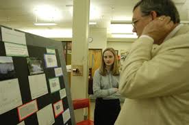 Morris Abernathy, Senior Sarah Perlinger explains her chemistry research to Library Director Steve Baker who is looking over - 3105-45