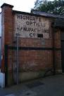 Notice painted on a wall showing the Highgate Optical &amp; Manufacturing Co., - via Daymix
