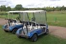 Two golf carts are parked overlooking this 18-hole course which stretches - via Daymix