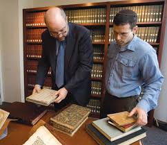 U.C. Berkeley law professor Ken Bamberger (left) and Rabbi David Kasher examine ancient Jewish law books. photo/james block - BAboalt