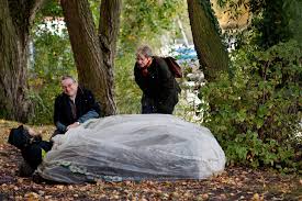 Psychiaterin Dorothee Freudenberg und Straßensozialarbeiter Thomas Kanehl sprechen mit einem Obdachlosen an seinem Stammplatz an der Alster