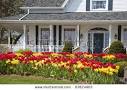 The Front Of A House With Large Flower Beds Full Of Tulips. Stock ...