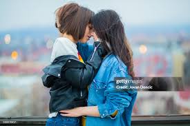 young lesbian kissing teen|Young lesbian couple with rainbow flag kissing during pride parade Stock  Photo by vadymvdrobot