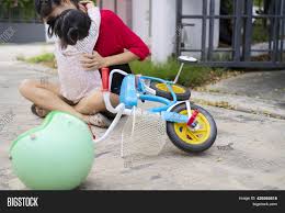 daugther sit and riding|Mother and daughter riding bicycle, daughter wearing helmet sitting in children's  seat stock photo